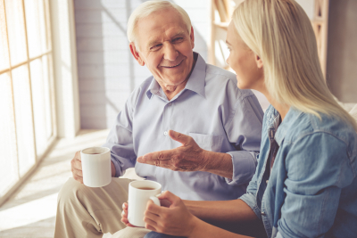 caregiver and senior man having a conversation while drinking a tea