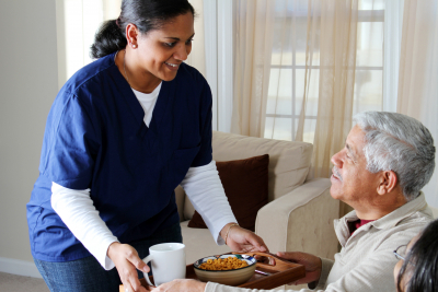 caregiver serving a meal to the senior man